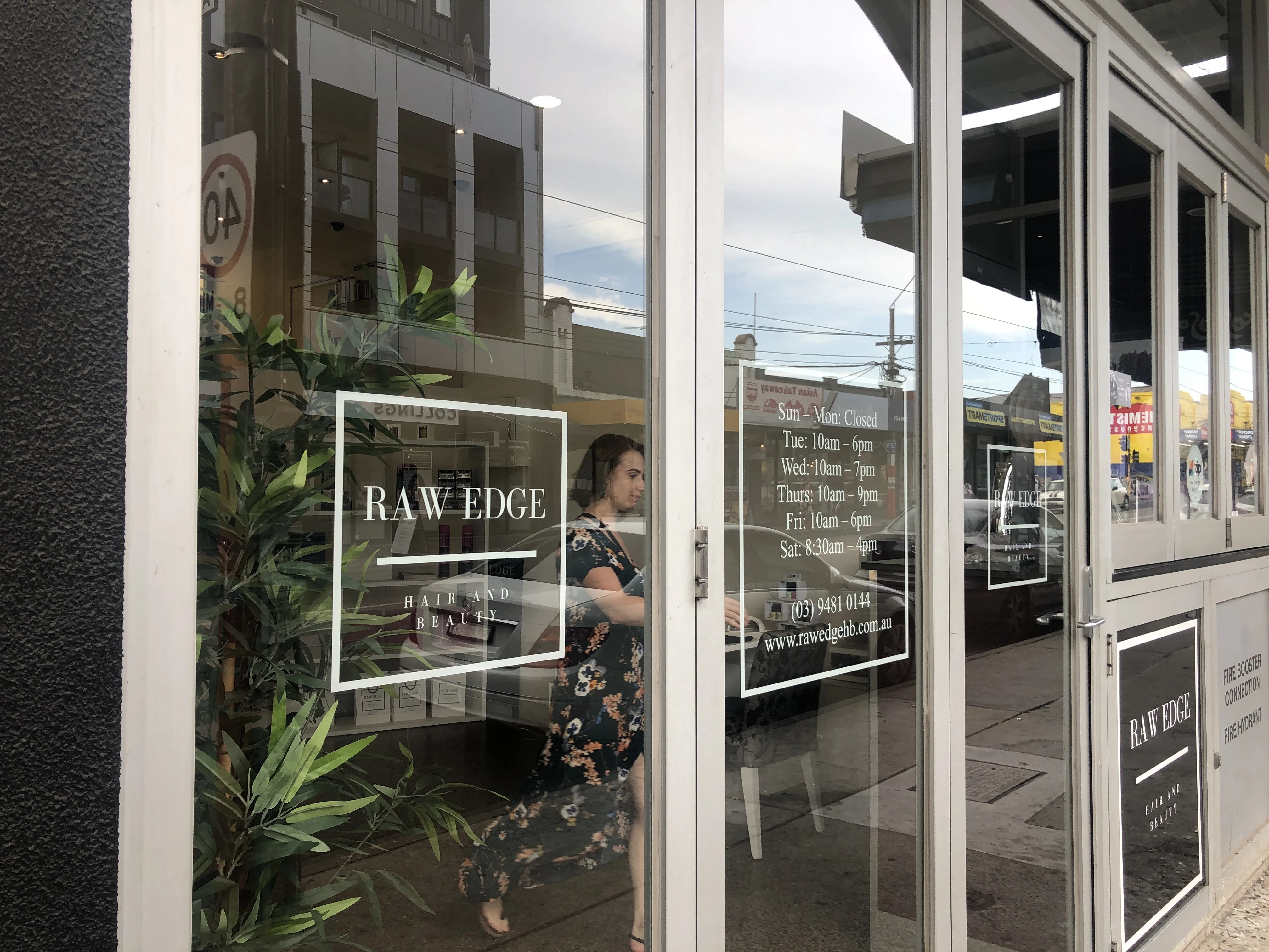 Raw Edge Hair and Beauty shopfront on High Street Northcote, wordmark and hours etched on glass